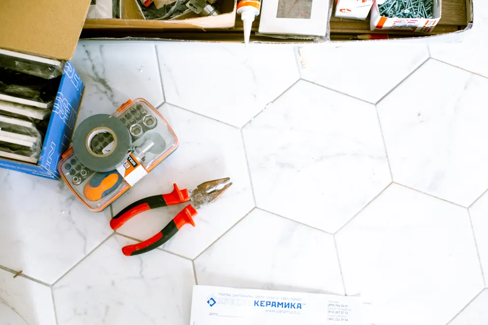A selection of property maintenance tools on a tiled floor